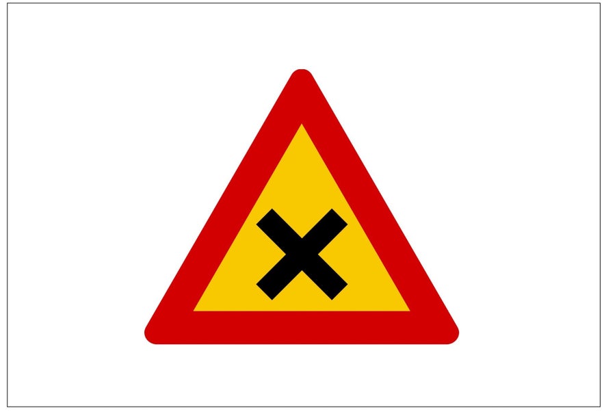 A yellow triangular road sign in Iceland with a red border and black X in the middle indicates a dangerous intersection.