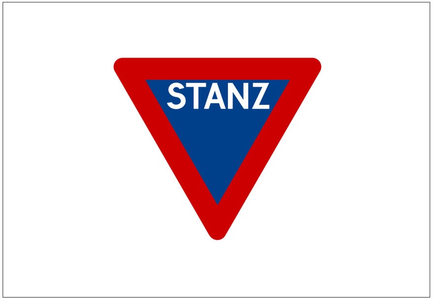 An outdated stop sign in Iceland shows an upside-down triangle shape, a red border, a blue background, and the word STANZ on it.