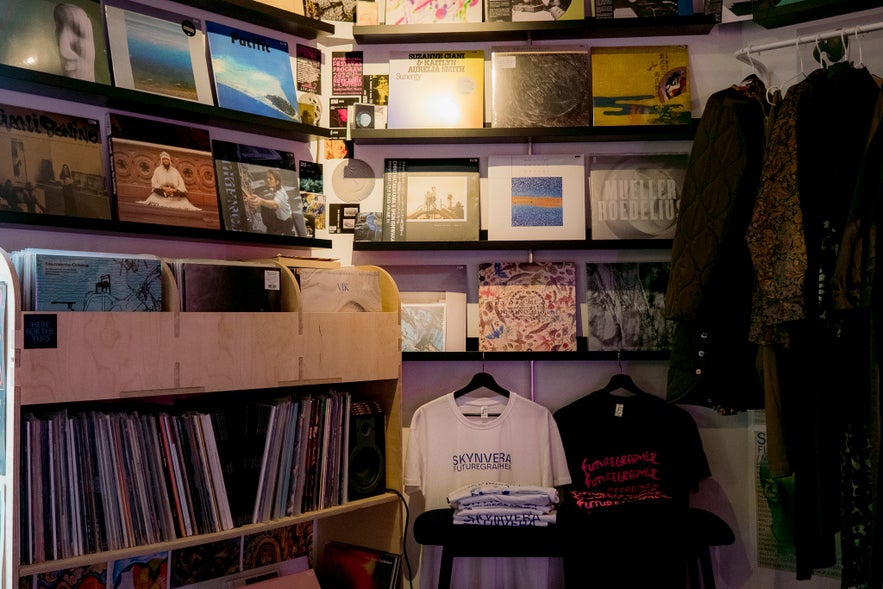Interior of Space Odyssey record shop in Reykjavik with vinyl records on shelves and clothing displayed on racks.