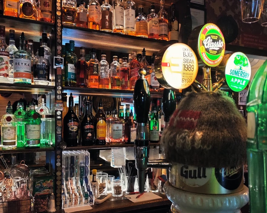 Shelves of whisky and spirits with beer taps at Den Danske Kro bar in downtown Reykjavík.