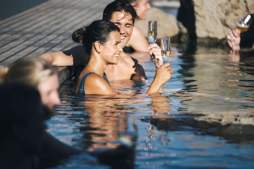 People enjoying drinks at the Hvammsvik hot springs