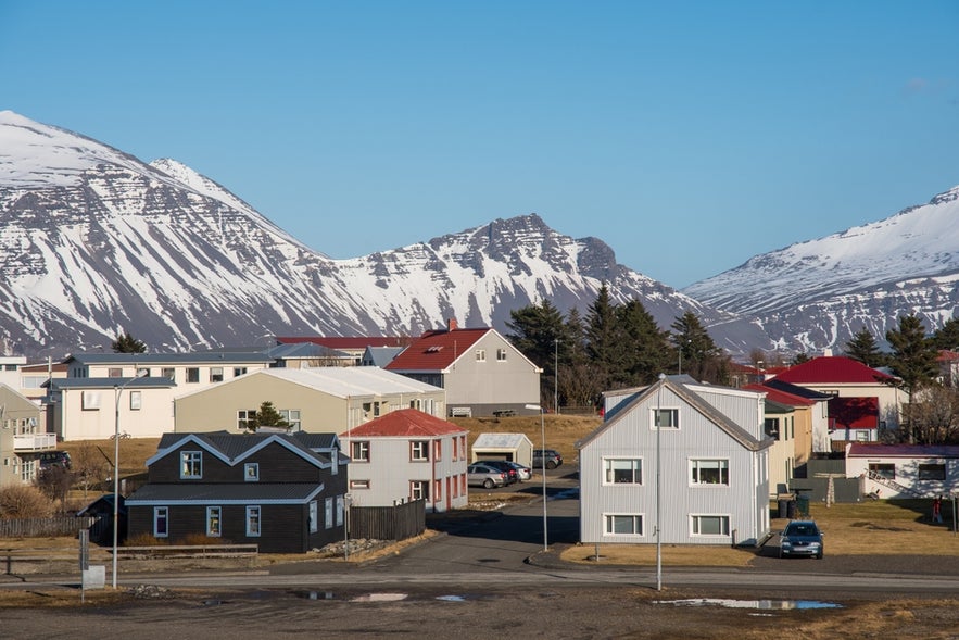 Old buildings in the town of Hofn in South Iceland, with snow-capped mountains in the background.