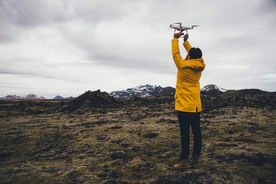 Ein Drohnenpilot bereitet sich auf Luftaufnahmen im Hochland Islands vor. Dabei fliegt er Drohnen durch Islands wilde Natur.