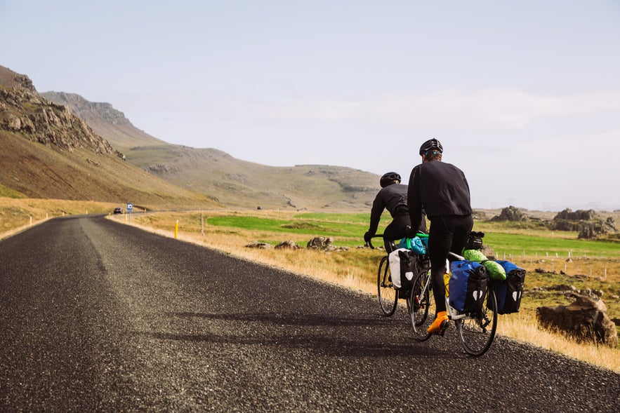 Two cyclists riding along the Ring Road, showcasing eco-friendly and scenic transportation in Iceland.