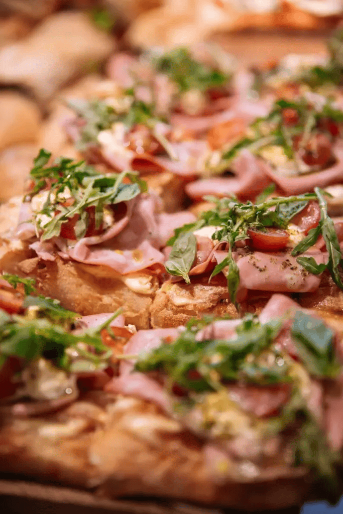 Freshly made open-faced sandwiches with ham, tomatoes, and arugula at Sandholt Bakery in Reykjavik