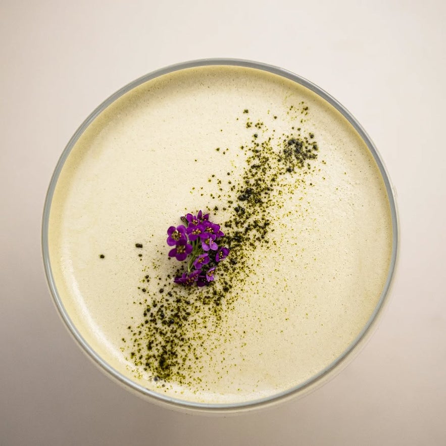 Matcha martini garnished with a purple flower at Kaffibrennslan café in Reykjavik.