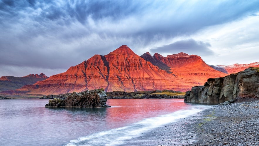 The best places to visit in East Iceland include Bulandstindur Pyramid Mountain glowing red at sunrise.