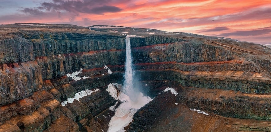 The best places to visit in East Iceland include Hengifoss Waterfall with red basalt cliffs and stunning views.