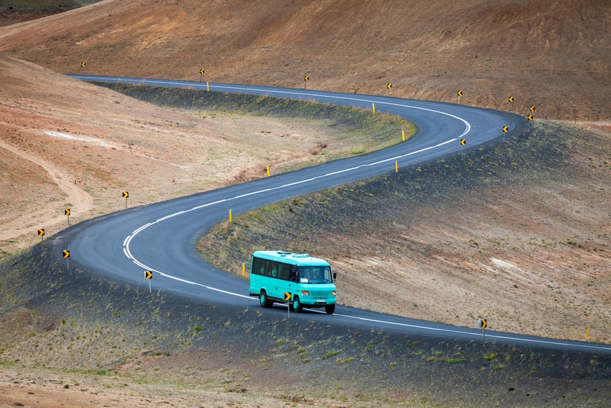 Scenic drive by bus to Lake Myvatn in North Iceland with winding roads and lava fields.