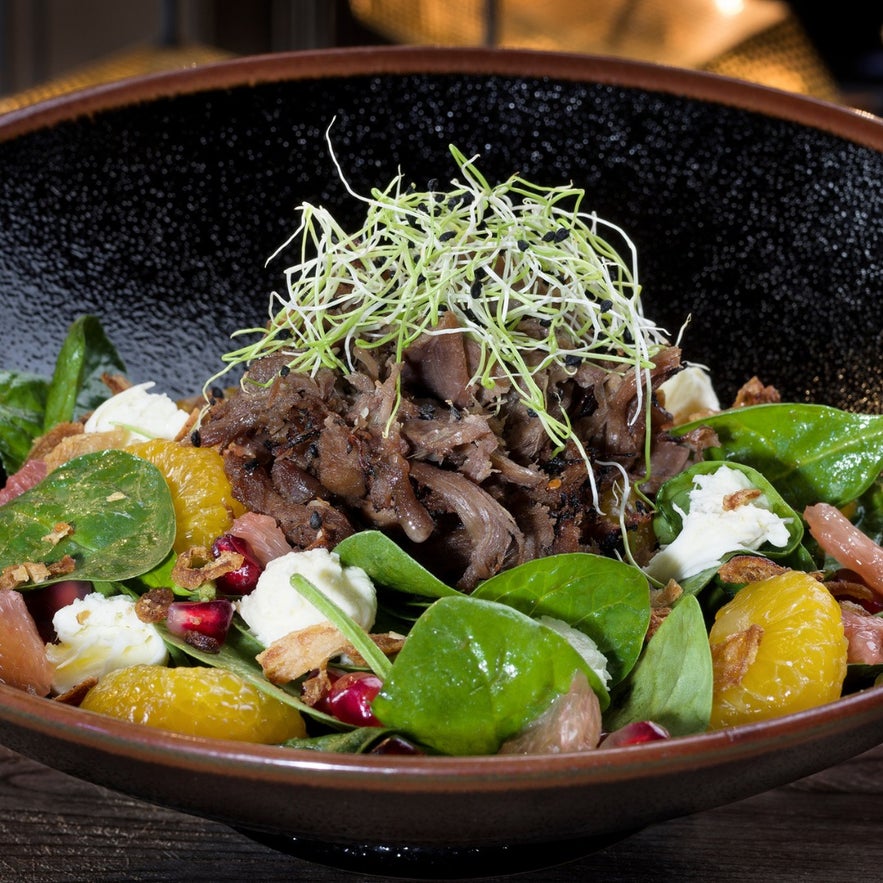 Gourmet salad with lamb, spinach, and fresh fruit at Grillmarkadurinn Restaurant in Iceland.