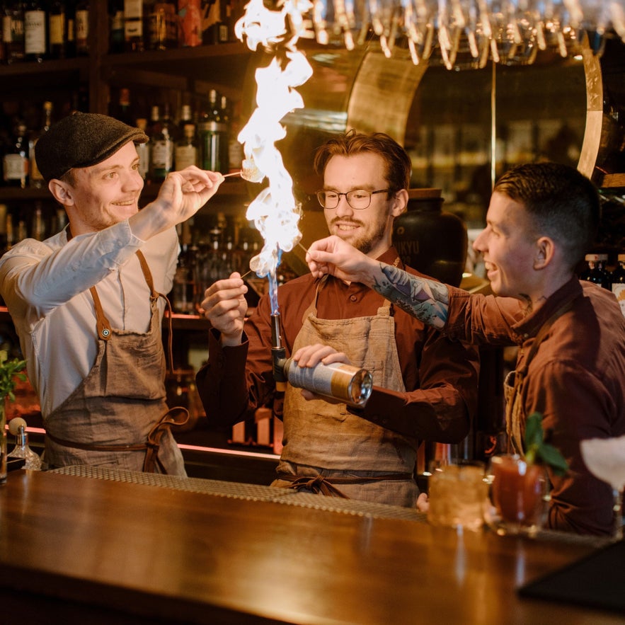 Bartenders creating flaming cocktail show at Monkeys Food & Wine Restaurant in Reykjavik.