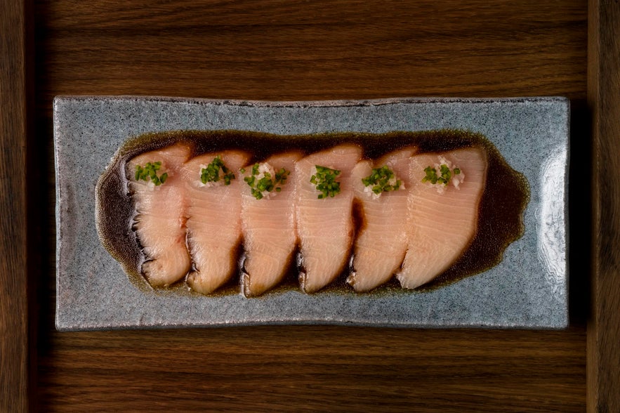 Fresh sashimi served with soy sauce and garnish at Fiskmarkadurinn in Reykjavik.