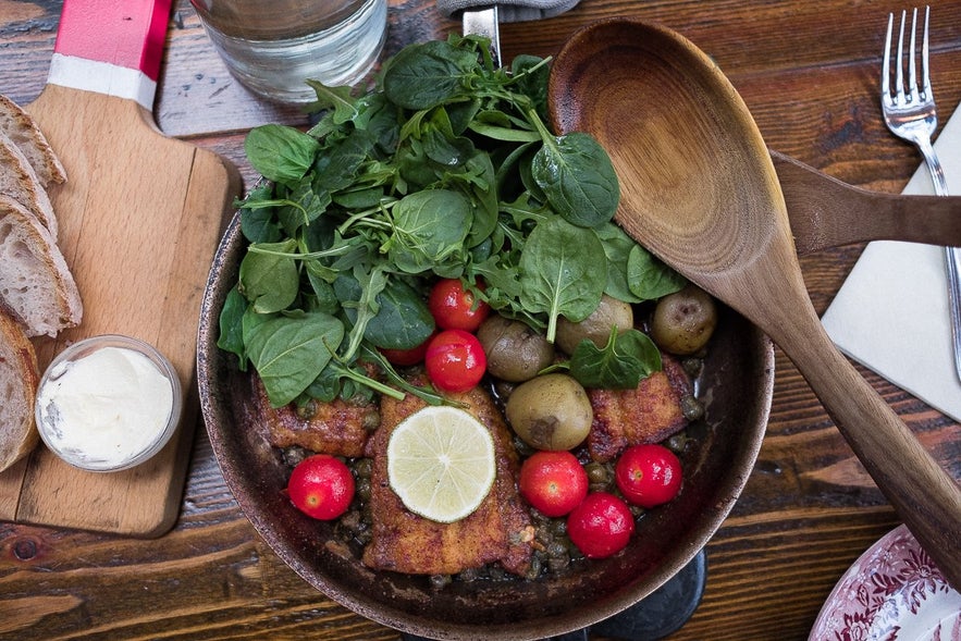 Traditional Icelandic meal with fish, potatoes, greens, and bread served at Messinn Restaurant in Reykjavik.
