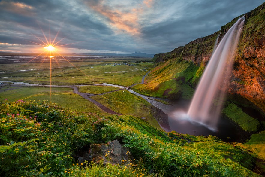 Sunset view over Seljalandsfoss Waterfall in South Iceland, a must-see spot near popular northern lights in Iceland tours.