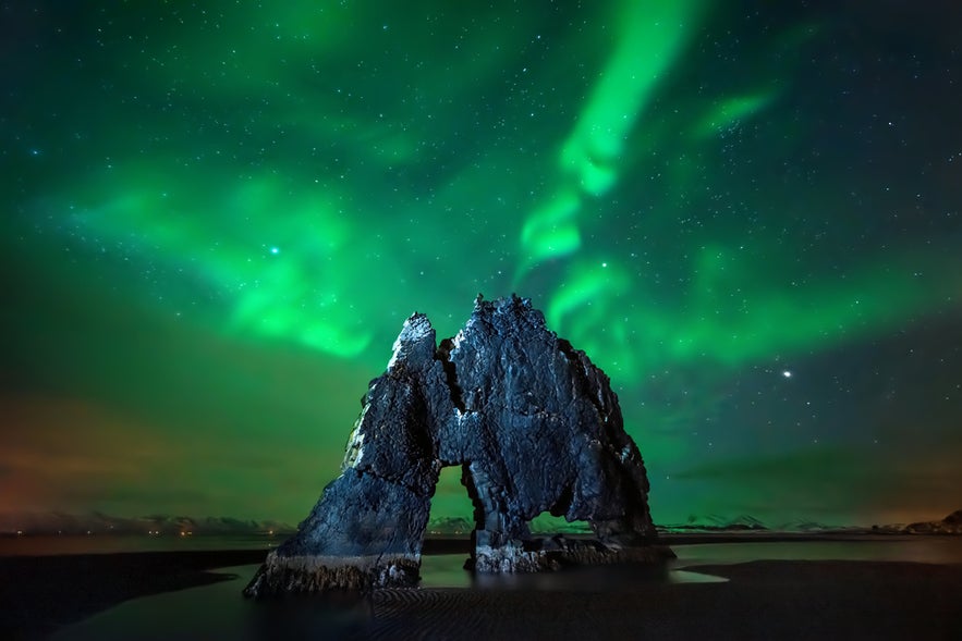 Hvitserkur Rock Formation in North Iceland is one of the hidden gems in Iceland, seen here under the northern lights.