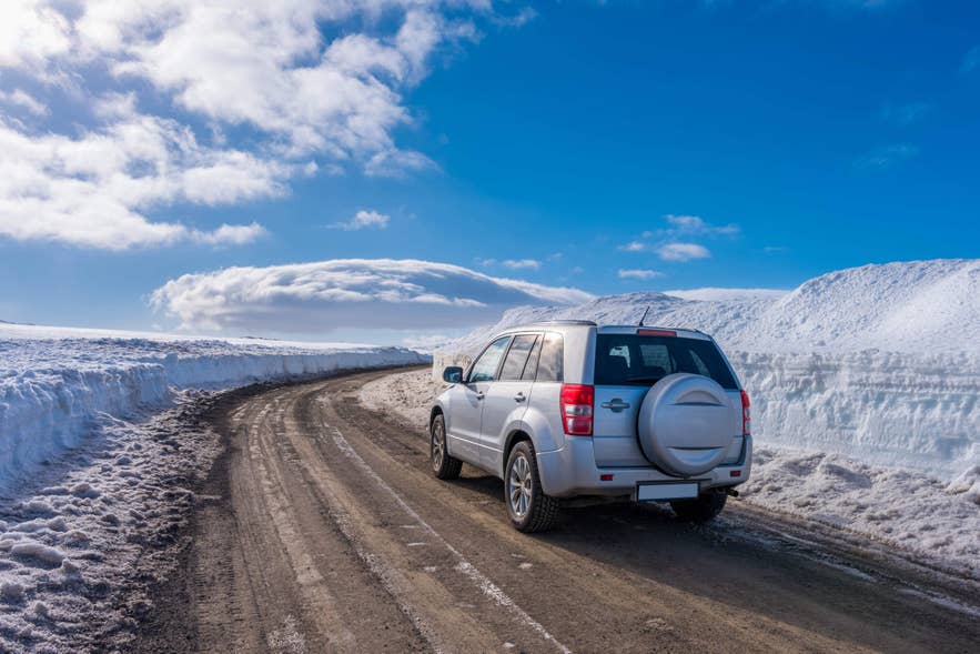 冬季积雪覆盖的环城公路上的汽车——这是游客参加冰岛多日旅行团时常见的景象。