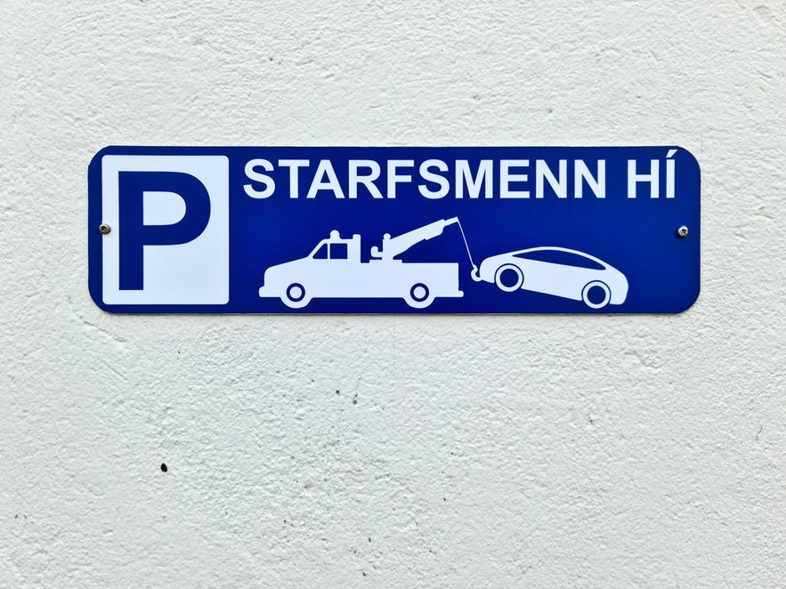 Tow-away sign in Reykjavik highlighting strict parking fines in Iceland for unauthorized cars.
