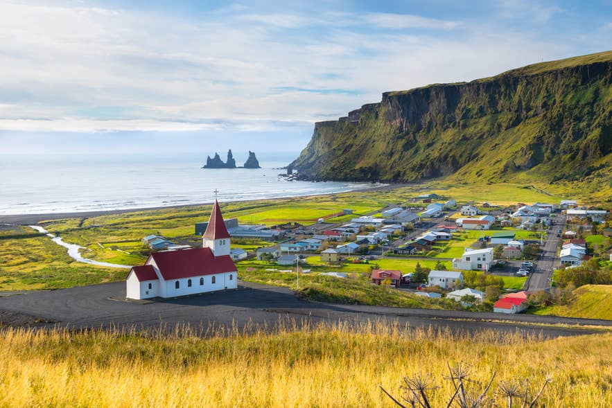Malowniczy widok na miejscowość Vik i morskie iglice Reynisdrangar w południowej Islandii, jedno z najlepszych miejsc na nocleg.