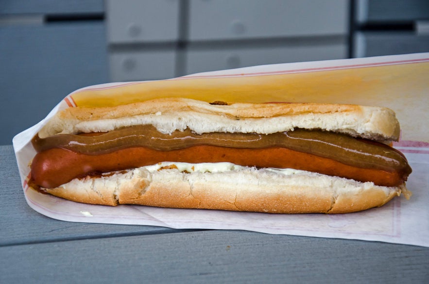 Classic Icelandic hot dog in a bun with toppings, a staple street food in Reykjavik enjoyed by both locals and visitors alike.