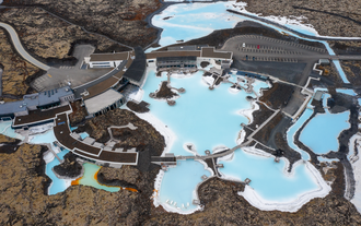 Aerial view of the Blue Lagoon’s bright blue geothermal pools surrounded by lava fields in Iceland.