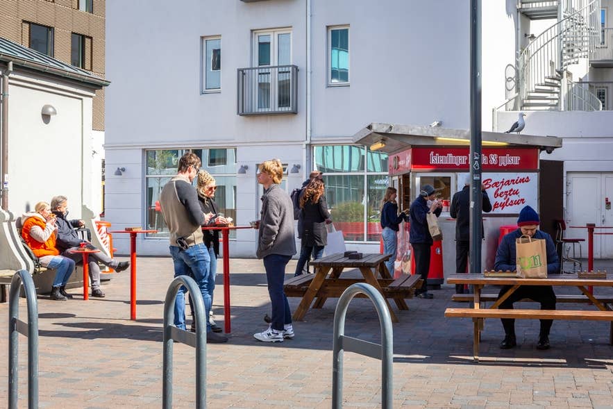 Bæjarins Beztu Pylsur hot dog stand in Reykjavik with people eating outside.”
