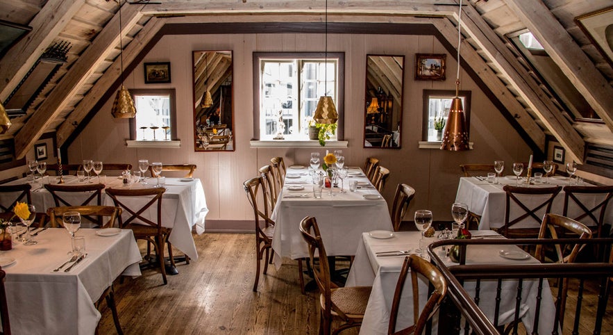 Caruso, an Italian restaurant in Reykjavik with cozy rustic interior and tables set for dining. Caruso, an Italian restaurant in Reykjavik with cozy rustic interior and tables set for dining.