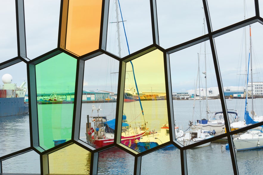 Facade detail of Harpa Concert Hall with view of port Reykjavik, across the windows.