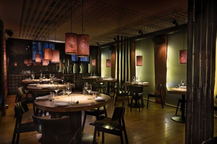 Elegant interieur van Fish Market in Reykjavik, met moderne tafels voor verfijnd dineren, warme verlichting en stijlvolle inrichting.