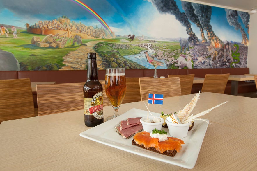 Traditional Icelandic food with beer at Café Loki in Reykjavik, featuring smoked salmon on rye bread, dried fish, and lamb slices.