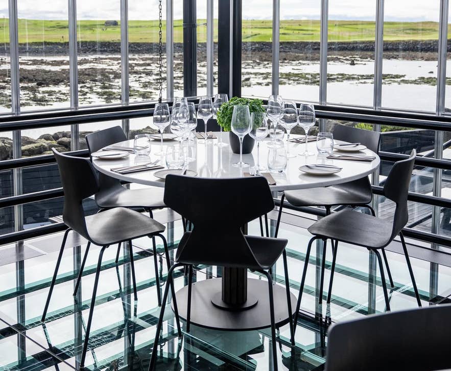 Restaurant Sol bij Reykjavik heeft een eetruimte met glazen wanden, een modern interieur en natuurlijk licht voor een lichte, stijlvolle sfeer. Restaurant Sol bij Reykjavik heeft een eetruimte met glazen wanden, een modern interieur en natuurlijk licht voor een lichte, stijlvolle sfeer.