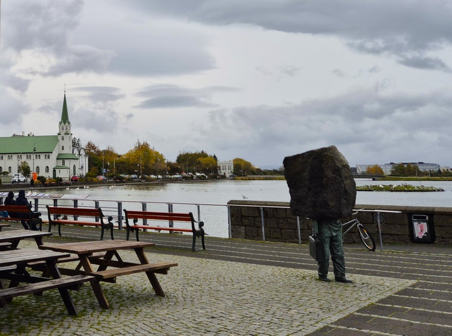 View of Reykjavik’s Tjornin Pond with sculpture of man carrying stone block