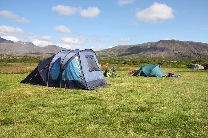 Leirar Campsite in Thingvellir National Park, Iceland, with tents set up on grassy fields beneath surrounding mountains.