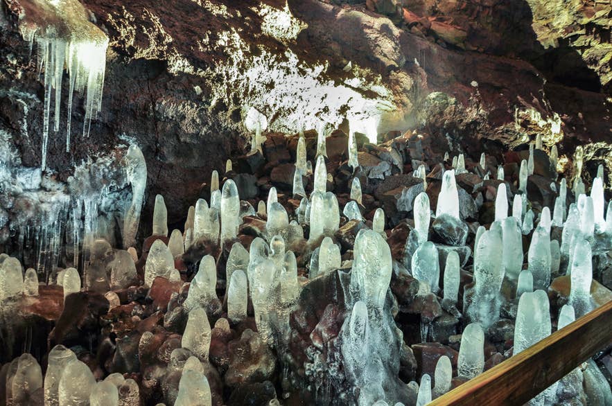 Ice formations rise from the floor of Vidgelmir lava cave in winter.