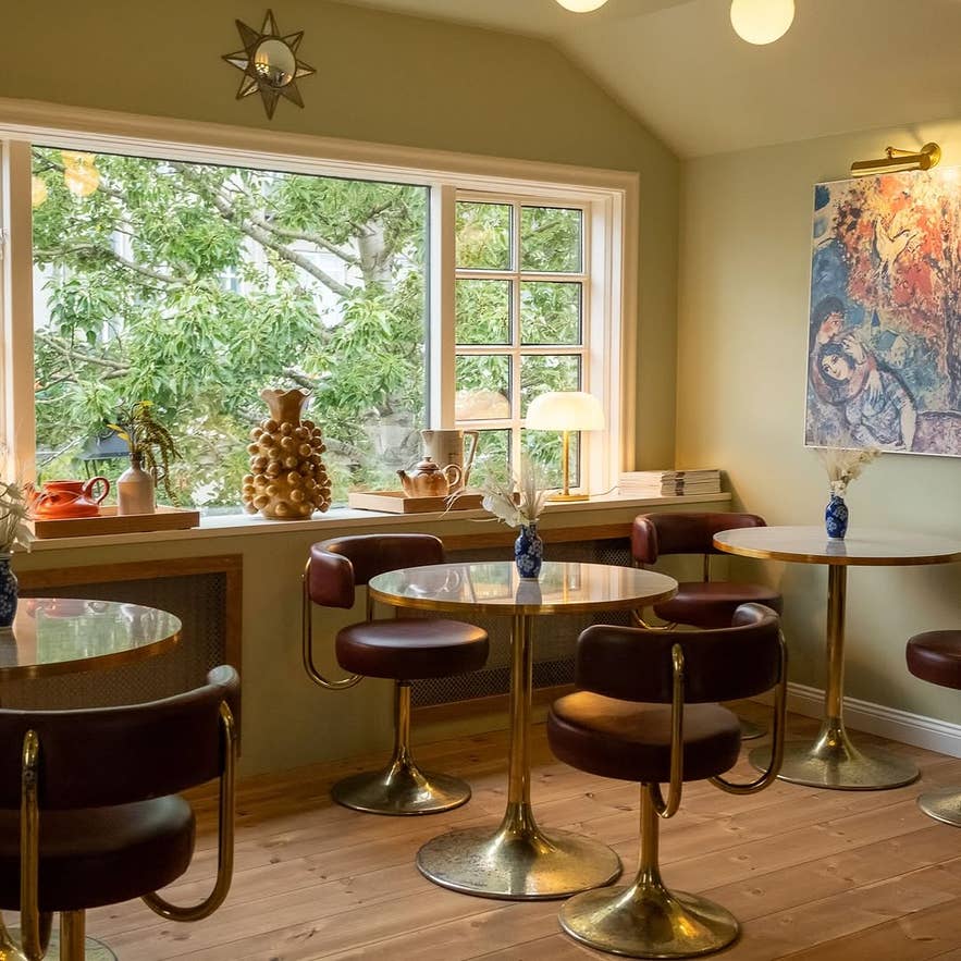 ห้องนั่งเล่นอบอุ่นพร้อมเก้าอี้และโต๊ะใกล้หน้าต่างที่ Barbara บาร์กาแฟและไวน์ชื่อดังในฮาฟนาร์ฟยอร์ดูร์