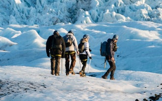 Gruppe von Reisenden mit Steigeisen auf einer Gletscherwanderung in Island