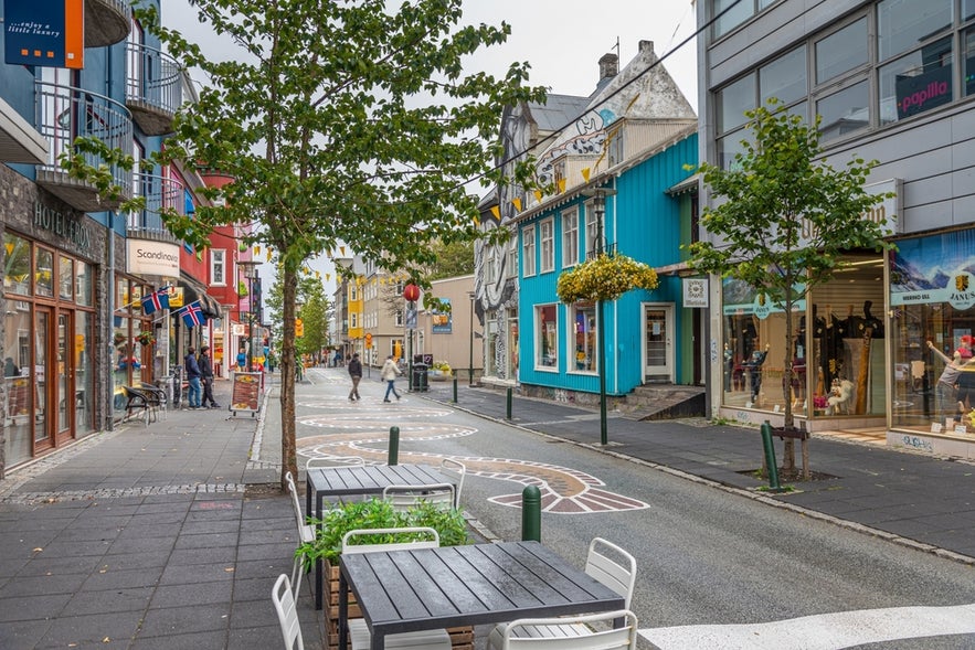 Colorful pedestrian shopping street with cafes and boutiques in Reykjavik.