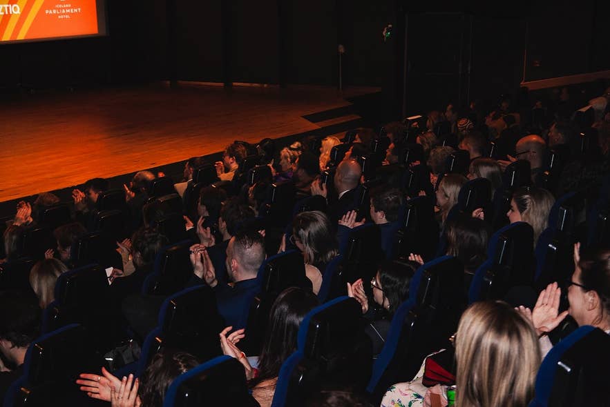 Audience seated in the theater during a live event at the Reykjavik International Film Festival.
