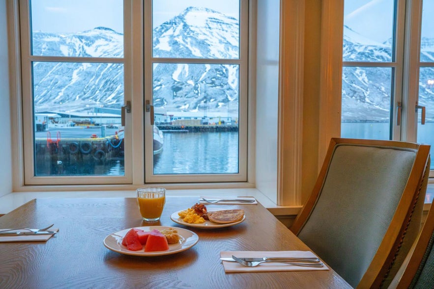 Breakfast with harbor and snowy mountain views from the dining area at Siglo Hotel in Siglufjörður, Iceland. Breakfast with harbor and snowy mountain views from the dining area at Siglo Hotel in Siglufjörður, Iceland.