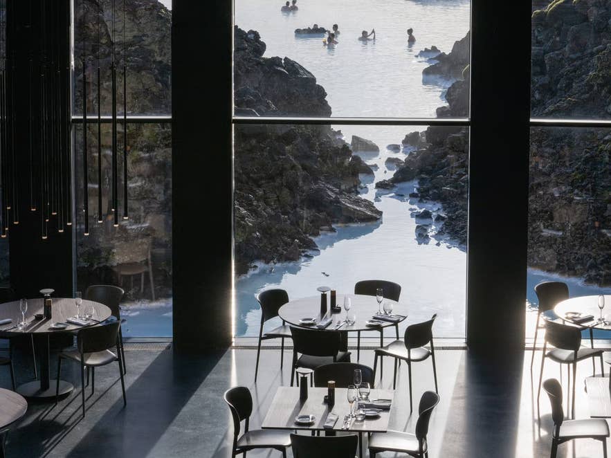 Ristorante del Silica Hotel con ampie finestre affacciate sulla Laguna Blu; i commensali ammirano le acque geotermiche.