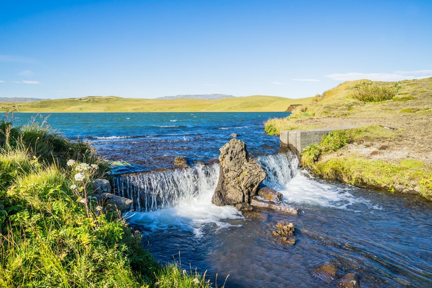 Systrafoss waterfall in Iceland flowing from a lake on a sunny summer day.