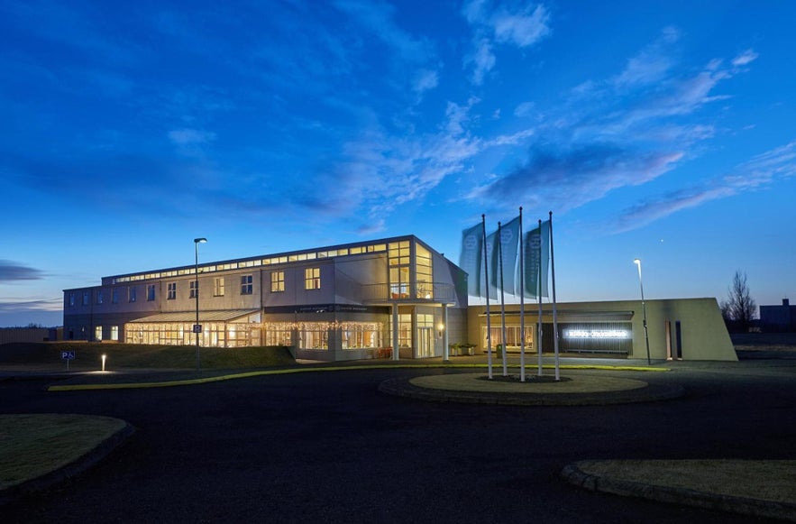 Hotel Klaustur in South Iceland illuminated at dusk with flags at the entrance.