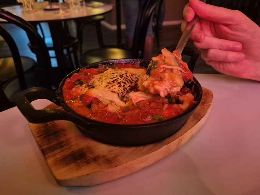 Close-up of baked eggplant parmigiana with tomato sauce and melted cheese at Litli Barinn in Reykjavik
