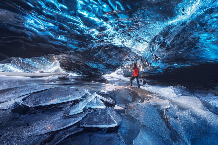 Reiziger verkent een schitterend blauwe ijsgrot in Vatnajokull Nationaal Park, een van de topactiviteiten in IJsland in januari