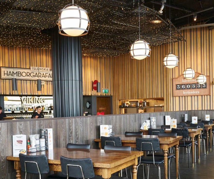 Hamborgarafabrikkan restaurant interior in Reykjavik, Iceland, featuring wooden tables, modern lighting, and cozy decor.