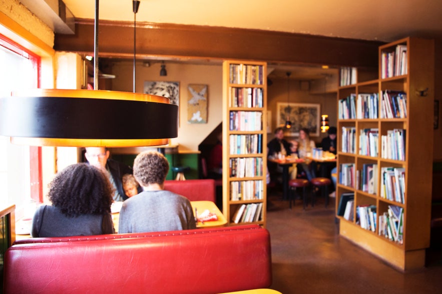 Inside the Grái Kötturinn café in Reykjavik with people enjoying food