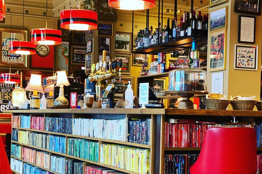 Laundromat Café’s book bar in Reykjavik with rainbow-colored shelves. 
