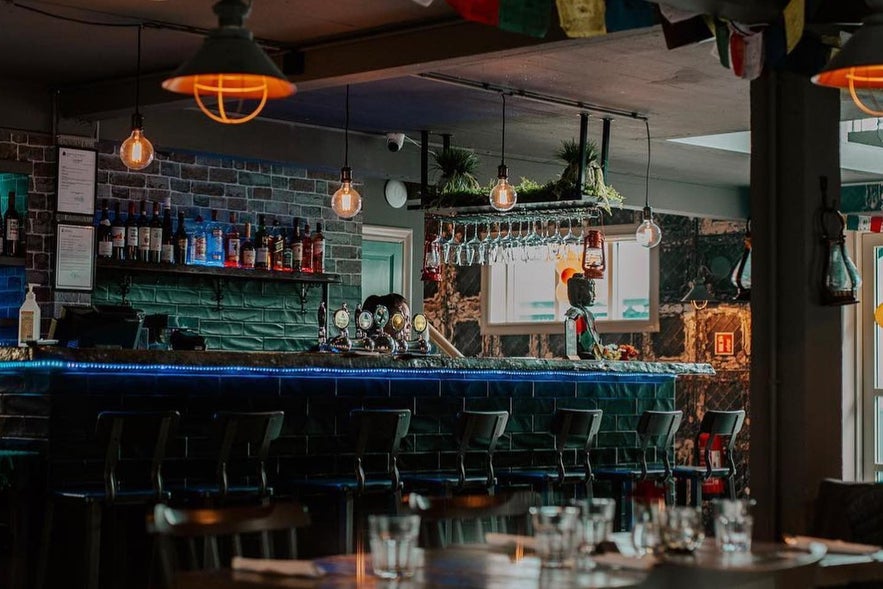Interior of Himalayan Spice in Reykjavik with bar counter, hanging lights, and dining setup.