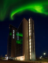 The Northern Lights dance gracefully over the Grand Hotel, painting the night sky with mesmerizing colors.