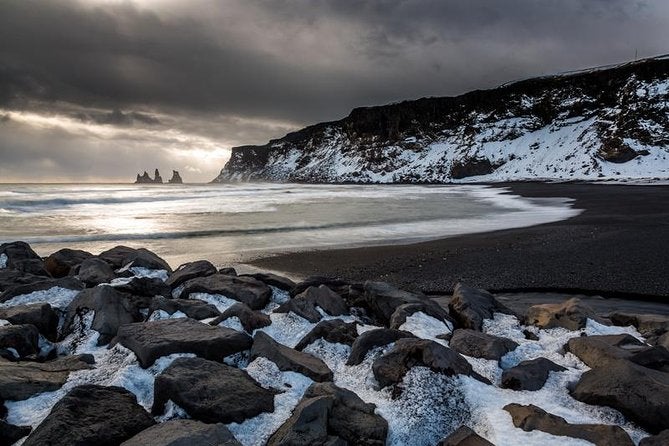 Marvel at the mysterious Reynisdrangar rock formations standing tall against the powerful waves of the North Atlantic Ocean.