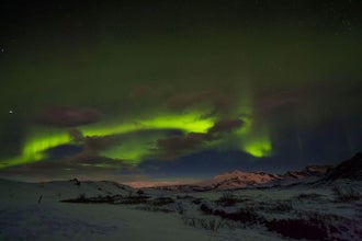Bands of green aurora borealis light up the countryside in Iceland.